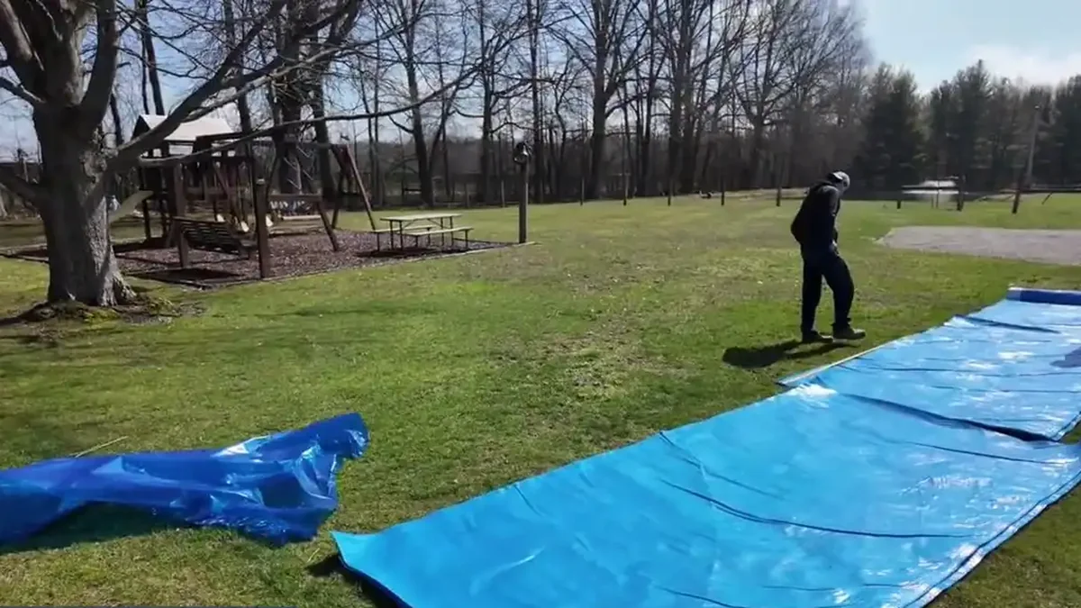 Crawl space liner material rolled out on a lawn before installation