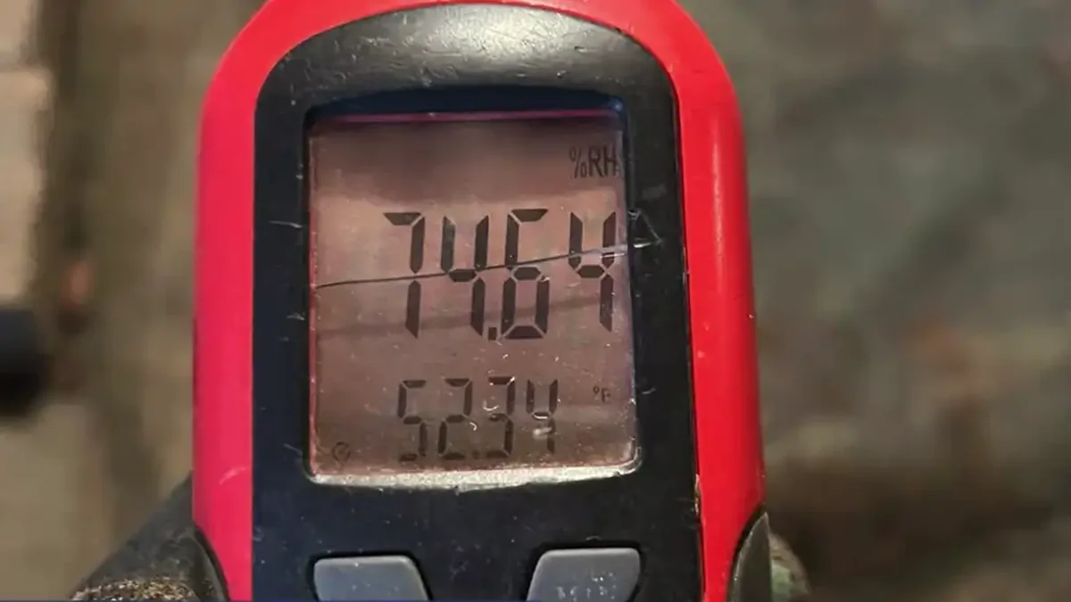 Hygrometer reading 74.6 percent relative humidity in a damp crawl space
