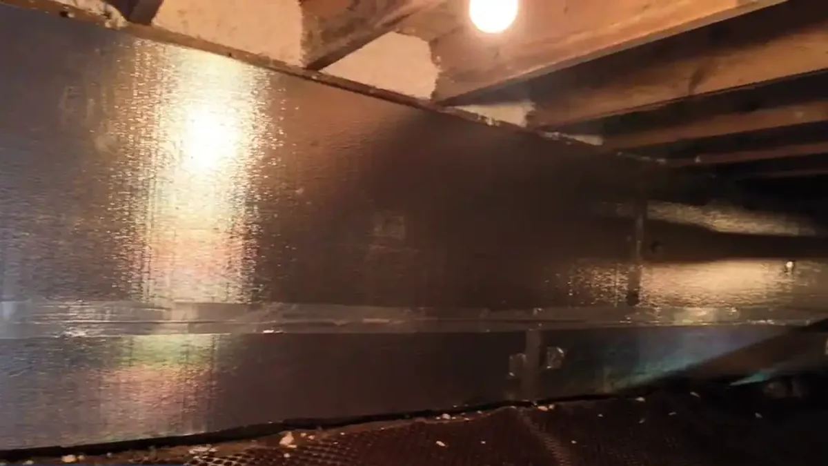 Foil-faced insulation installed on crawl space foundation walls above a sealed floor